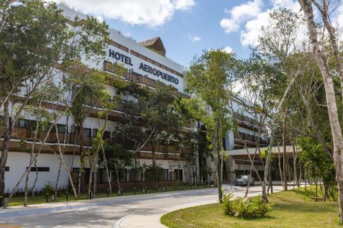 a building with trees in front of it at Hotel Mundo Maya Tulum Aeropuerto in Tulum
