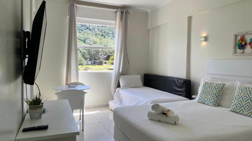 Una pequeña habitación con dos camas y una ventana. en Apart-Hotel Cavalinho Branco (311 e 409 ), en Águas de Lindóia