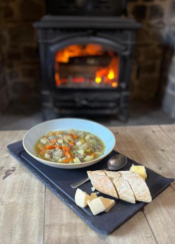 a plate of soup with bread and a plate of cheese at Suite 10 - Sleeping Giant Hotel - Pen Y Cae Inn in Brecon