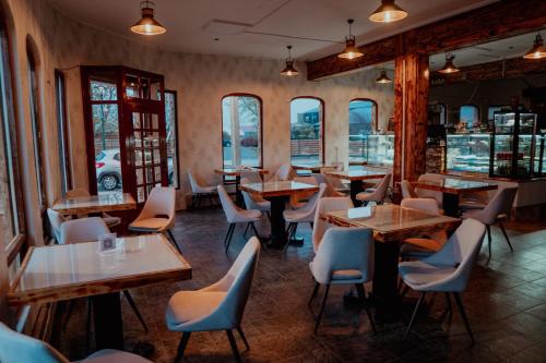 ein Restaurant mit Tischen und Stühlen und Fenstern in der Unterkunft Darwin Hotel in Puerto Natales