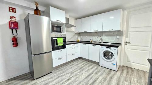 a kitchen with a refrigerator and a washing machine at Sol & Maré 2 in Calheta