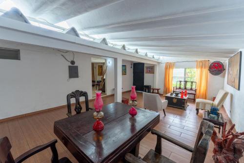 a living room with a wooden table with pink vases on it at Casa Punta Chame in Punta Chame