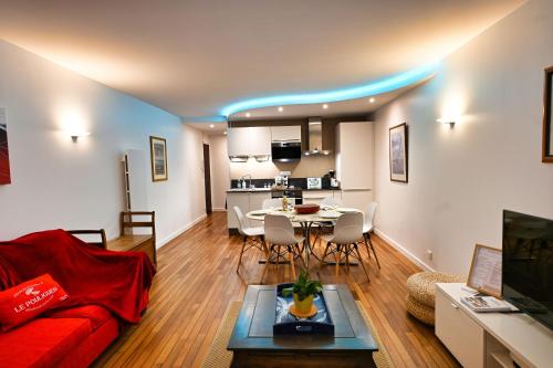 a living room with a red couch and a table at Le Navire-Plage du Nau-Parc-Résidence calme-Garage in Le Pouliguen