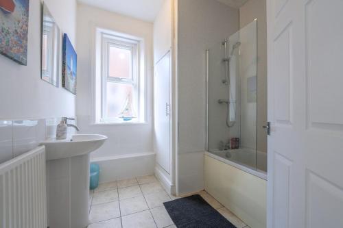 a white bathroom with a sink and a shower at The Lytham Retreat - New! Spacious & Luxurious in Lytham St Annes