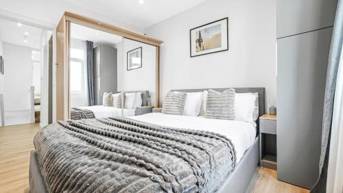 a bedroom with a large bed and a mirror at Stylish 2-Bed flat in E17 in London
