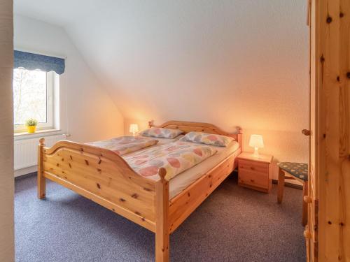 a bedroom with a wooden bed and a window at Norderhof Hansen - Ferienhaus in Nordstrand