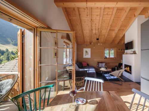 a room with a table and chairs and a living room at BLUE ALPINE Lodge bis 6 Gäste, Cheminée, 400 m zum Skilift in Sedrun