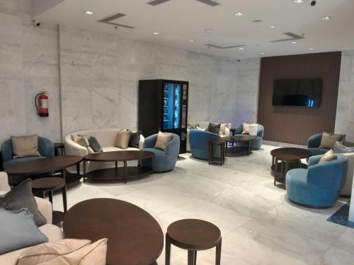 un hall d'entrée avec des canapés, des chaises et des tables dans l'établissement فندق دفلى اثنان, à La Mecque
