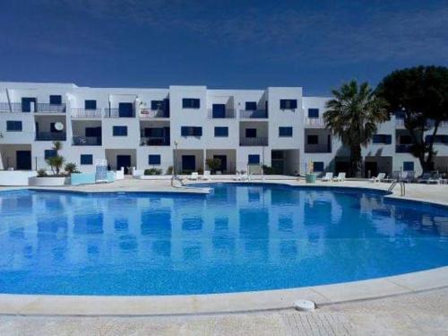 a large swimming pool in front of a building at Portimao in Bicas