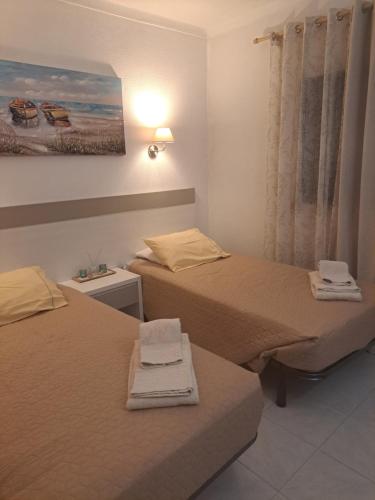 a room with two beds and a painting on the wall at Portimao in Bicas