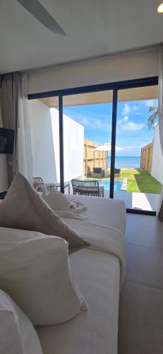 a row of beds in a room with a view of the ocean at ThreeTreesSamuiPoolVilla in Ban Thung