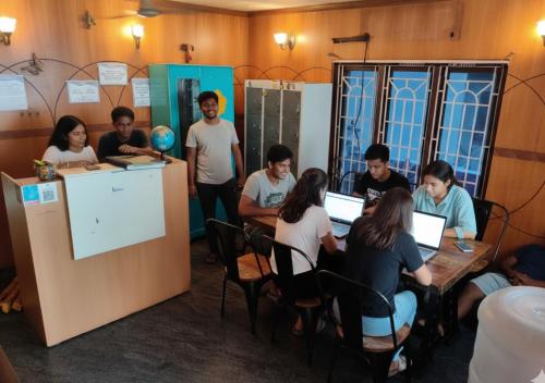 un gruppo di persone seduti intorno a un tavolo con computer portatili di The Sheltor a Chennai