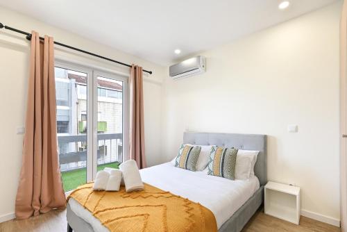 a bedroom with a bed and a large window at Largo da Estação Apartments By Sé Apartamentos in Braga