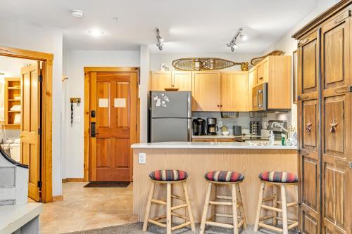 a kitchen with wooden cabinets and bar stools at Buffalo Lodge 8351 in Keystone