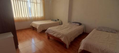 a room with two beds and a window in it at Apartment, with kitchen, garage and laundry in Tacna