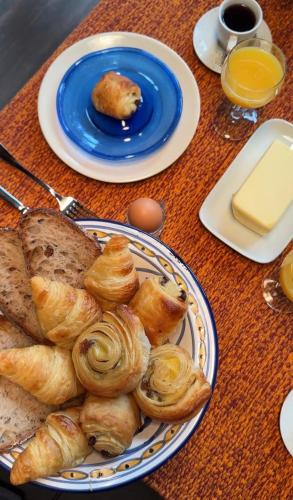 ein Tisch mit Tellern mit Gebäck und einem Teller mit Brot in der Unterkunft Le Secret in Lusigny