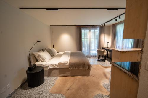 een slaapkamer met een bed en een bureau erin bij Chalet Gutsch Andermatt by HomeFlow in Arni Alp