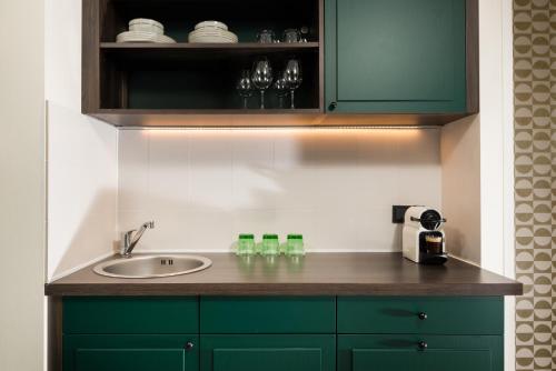 a bathroom counter with a sink and green cabinets at master Mirabell in Salzburg