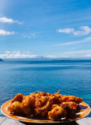 un piatto di cibo su un tavolo accanto all'acqua di Humble Homestay a Besir