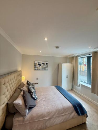 ein Schlafzimmer mit einem großen Bett und einem großen Fenster in der Unterkunft Cozy Flat with garden in Prime Location in Brentford