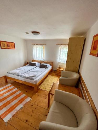a bedroom with a bed and a couch and chairs at Penzion U Cempu in Kunratice