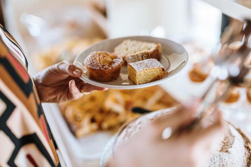 a person holding a plate with pastries on it at Villa Di Sotto in Castelnuovo Berardenga