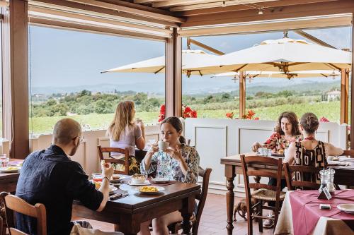 a group of people sitting at a table in a restaurant at Villa Di Sotto in Castelnuovo Berardenga