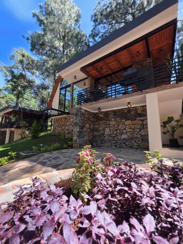 a house with purple flowers in front of it at Chalet San Marcos in Mazamitla