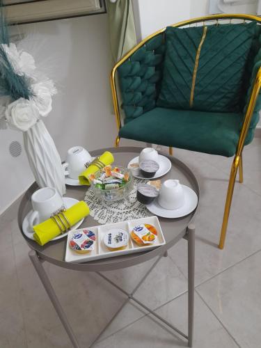 a table with a tray of food and a green chair at Falanga Family Guests Accommodation in Civitavecchia