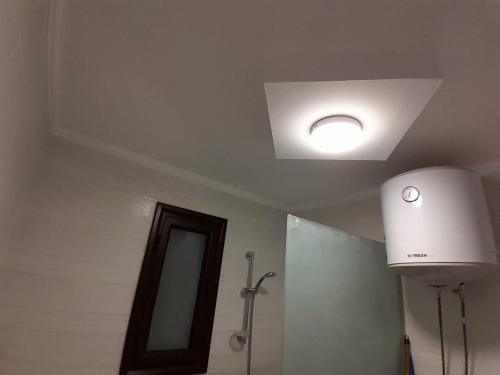 La salle de bains est pourvue d'une lampe de plafond et d'un miroir. dans l'établissement Turtles Beach resort hourghada Studio view sea view pool private beach jacuzzi pools air-conditioned restaurant on the beach jacuzzi security and a large sunny balcony, à Hurghada