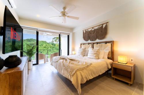 une chambre avec un lit et une grande fenêtre dans l'établissement 3077 - Solana B203, à Santa Cruz Huatulco