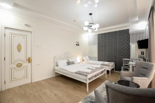 a bedroom with a bed and a couch and a chair at Hotel Harmony Premium in Kutaisi