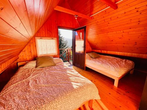 una camera da letto con un letto in una cabina di legno di Świerkowa Chata a Targanice