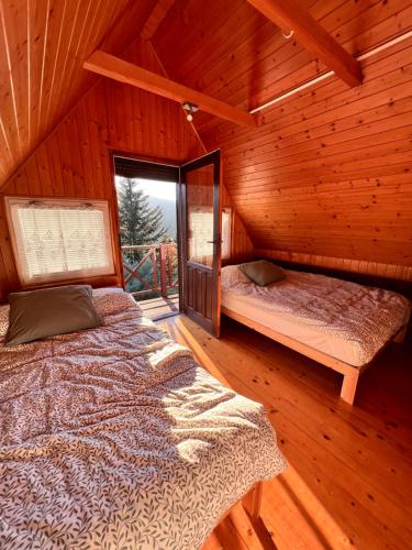 1 Schlafzimmer mit 2 Betten in einer Holzhütte in der Unterkunft Świerkowa chata in Targanice