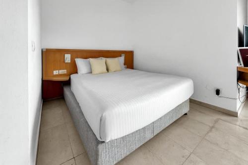 a bed in a room with a white bedvisor at Okeanos Sea Loft in Herzliya B
