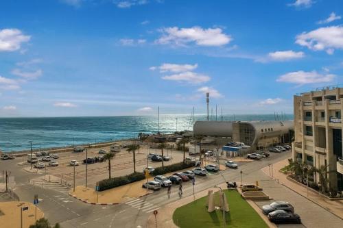 a parking lot with cars parked next to the ocean at Okeanos Sea Loft in Herzliya B