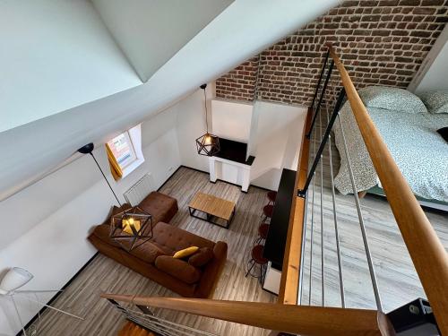 an attic room with a staircase and a couch at Charmant Duplex 4 pers Au centre Douai Netflix in Douai