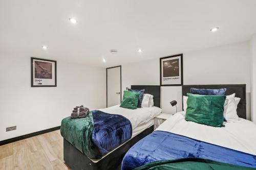 Dos camas en una habitación con verde y blanco. en Sleek and Stylish Yorkshire Gem - Sleeps 4, en Castleford