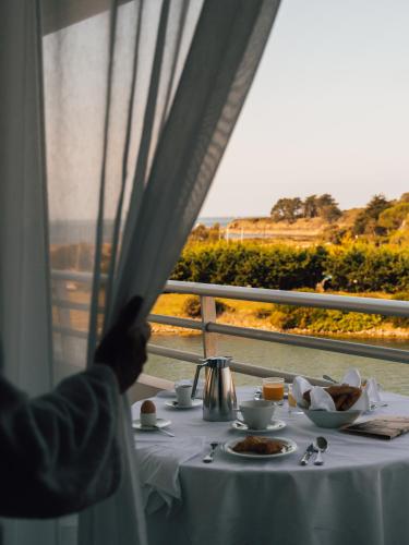 阿尔宗Miramar La Cigale Hotel Thalasso & Spa的一张桌子,上面放着一盘食物,还有一个窗口