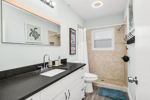 a bathroom with a sink and a toilet at Relaxing Salt Pool & Spa, Walk to Key Lime House! in Lantana