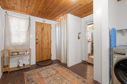 eine Waschküche mit einer Tür, einer Waschmaschine und einem Trockner in der Unterkunft Central Location - Adorable Adobe - King and Queen in Santa Fe