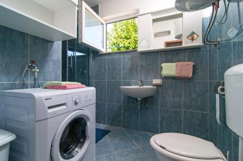 een badkamer met een wasmachine en een wastafel bij Holiday Home Ruda in Vinišće