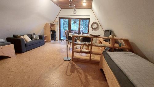 a living room with a bed and a desk at Ferienwohnung zum Holzwurm in Friedersdorf