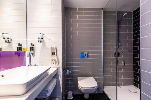 a bathroom with a sink and a toilet and a shower at Premier Inn Köln City Süd in Cologne