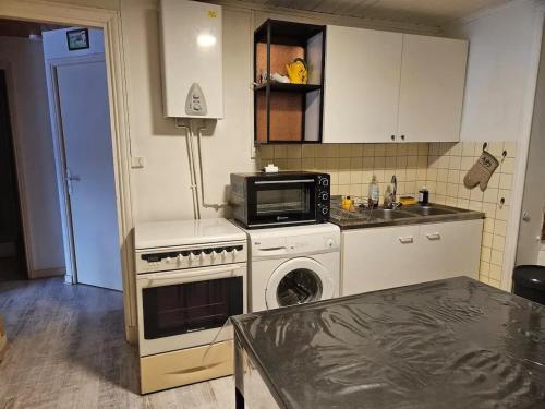 a kitchen with a microwave and a stove top oven at Maison charmante avec vue sur la montagne à Saint-Anthème in Faye-Furet