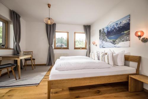 ein Schlafzimmer mit einem großen Bett und einem Schreibtisch in der Unterkunft Waldruh in Wiesing