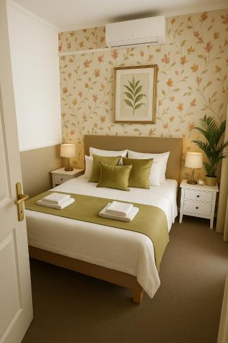 a bedroom with a large bed with two tables and two lamps at Amfora Panzió in Gyula