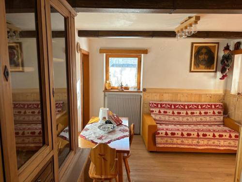 a small room with a bed and a table at Ciasa La Cate in Bellamonte