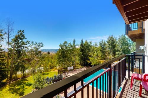 a balcony with a view of a pool and trees at Scandinavian Lodge 203 in Steamboat Springs