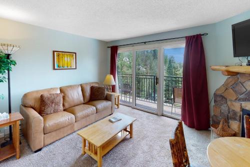a living room with a couch and a fireplace at Scandinavian Lodge 203 in Steamboat Springs